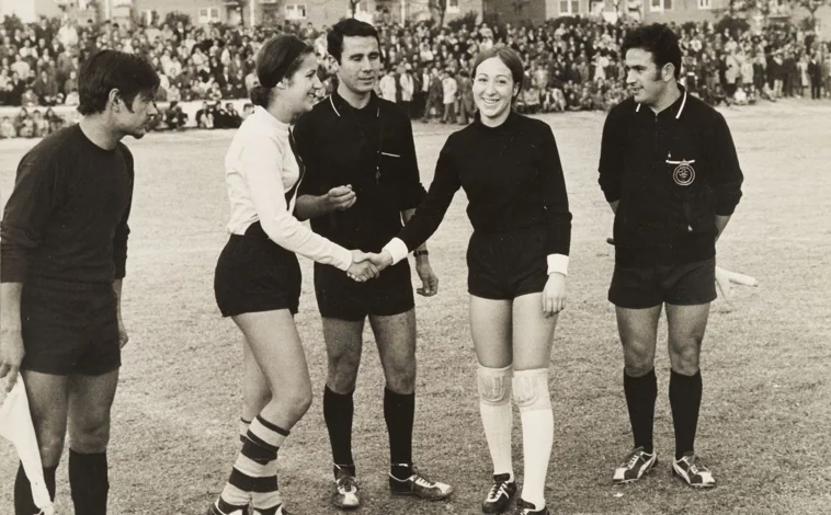 Imagen principal - Arriba, jugadoras de fútbol se saludan en presencia del árbitro al inicio del encuentro. Abajo, dos momentos de la confrontación entre las jugadoras del Sizam y el Mercacredit, en 1970 