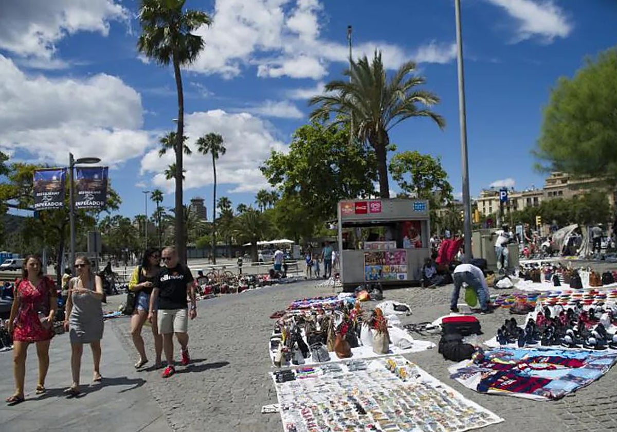 Turistas junto a varios puestos de venta ambulante en Barcelona