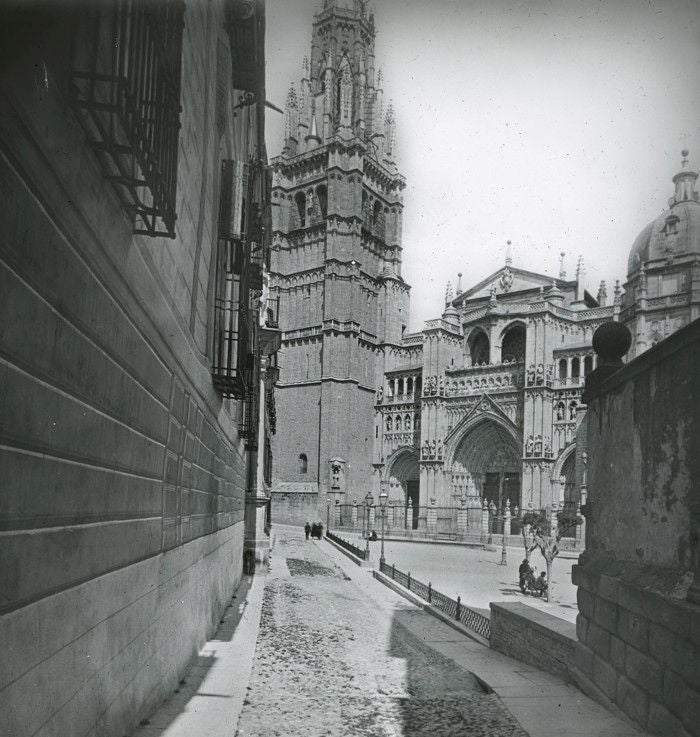 El proyecto de Santiago Martín delimitó el paseo central con líneas de pretiles con respaldos de hierro y faroles. La foto de un viajero francés (ca. 1910) captó desde la plaza del Consistorio, la calle sin escalones trazada ante el Palacio Arzobispal. A la derecha, una alta pared aislaba entonces de las vistas exteriores la terraza del Ayuntamiento. Archivo Municipal de Toledo