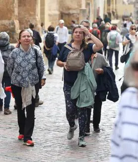 Imagen secundaria 2 - Arriba, agentes policiales en la zona del Casco; debajo, turistas por Torrijos y el Puente Romano