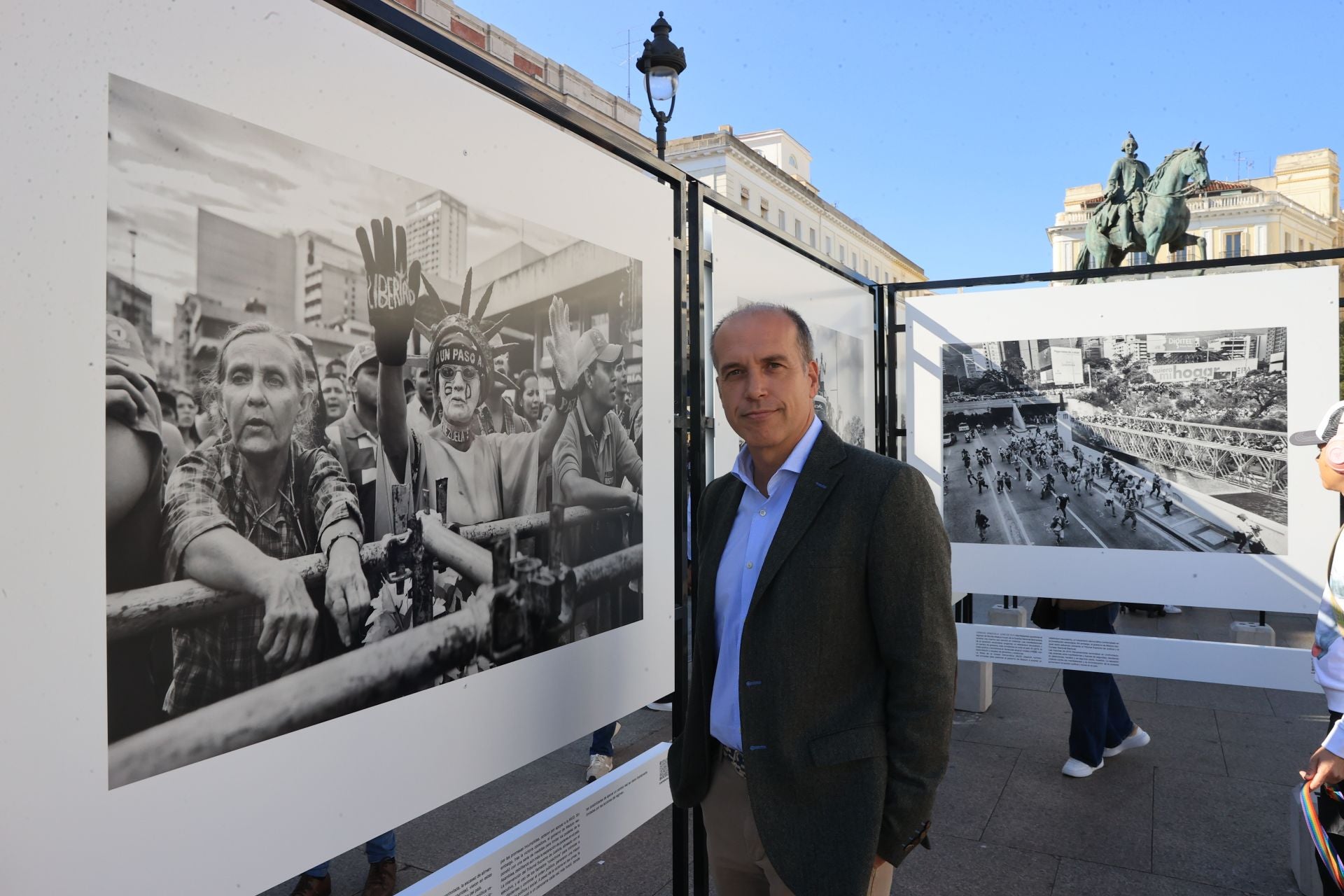 El reportero gráfico Álvaro Ybarra Zavala, junto a varias de sus instantáneas en la muestra 'Bolivariano'