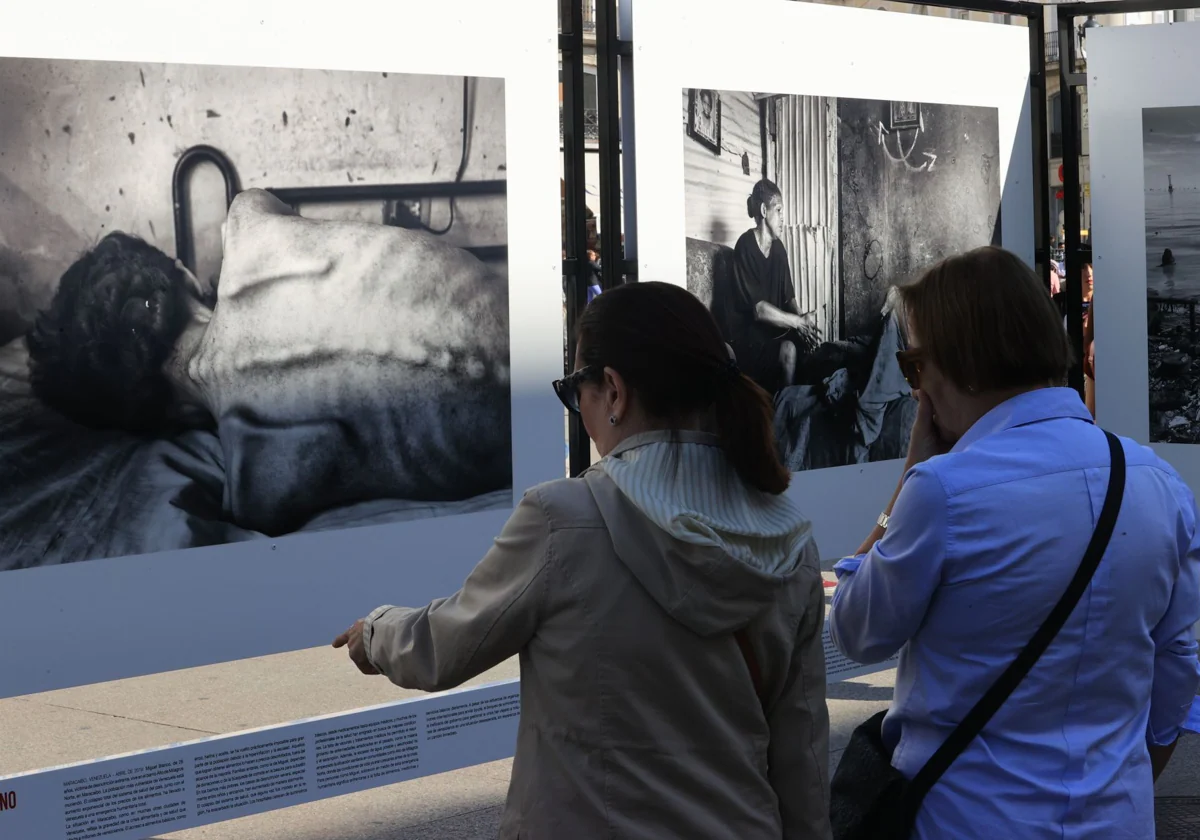 Dos mujeres contemplan una de las fotografías más impactantes de la exposición, la de un joven de 28 años seriamente desnutrido en Maracaibo