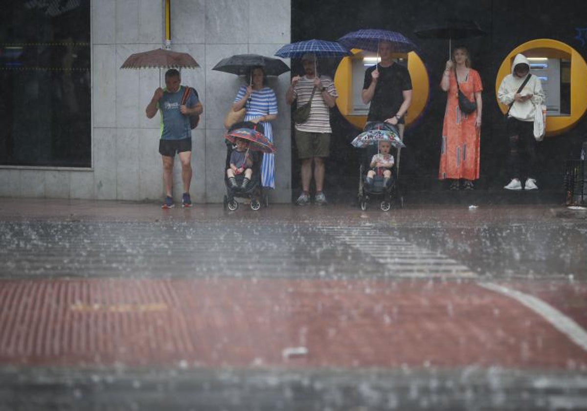 Varias personas se refugian de la lluvia en Valencia