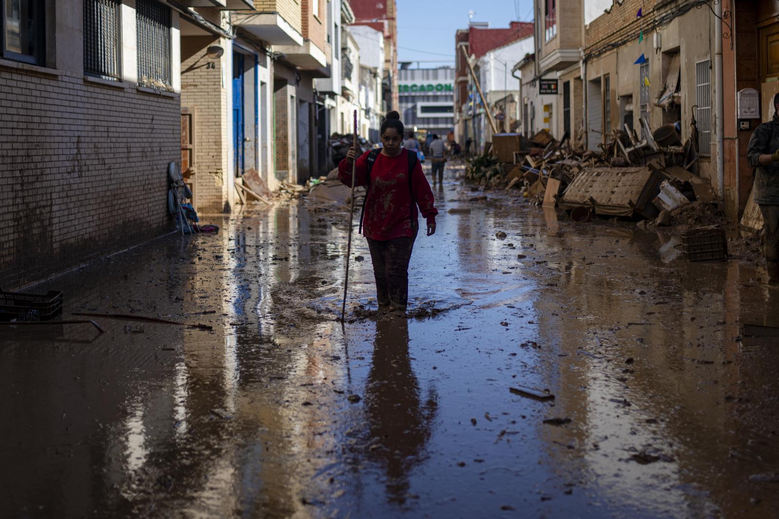 Varias personas retiran agua y barro, en Valencia