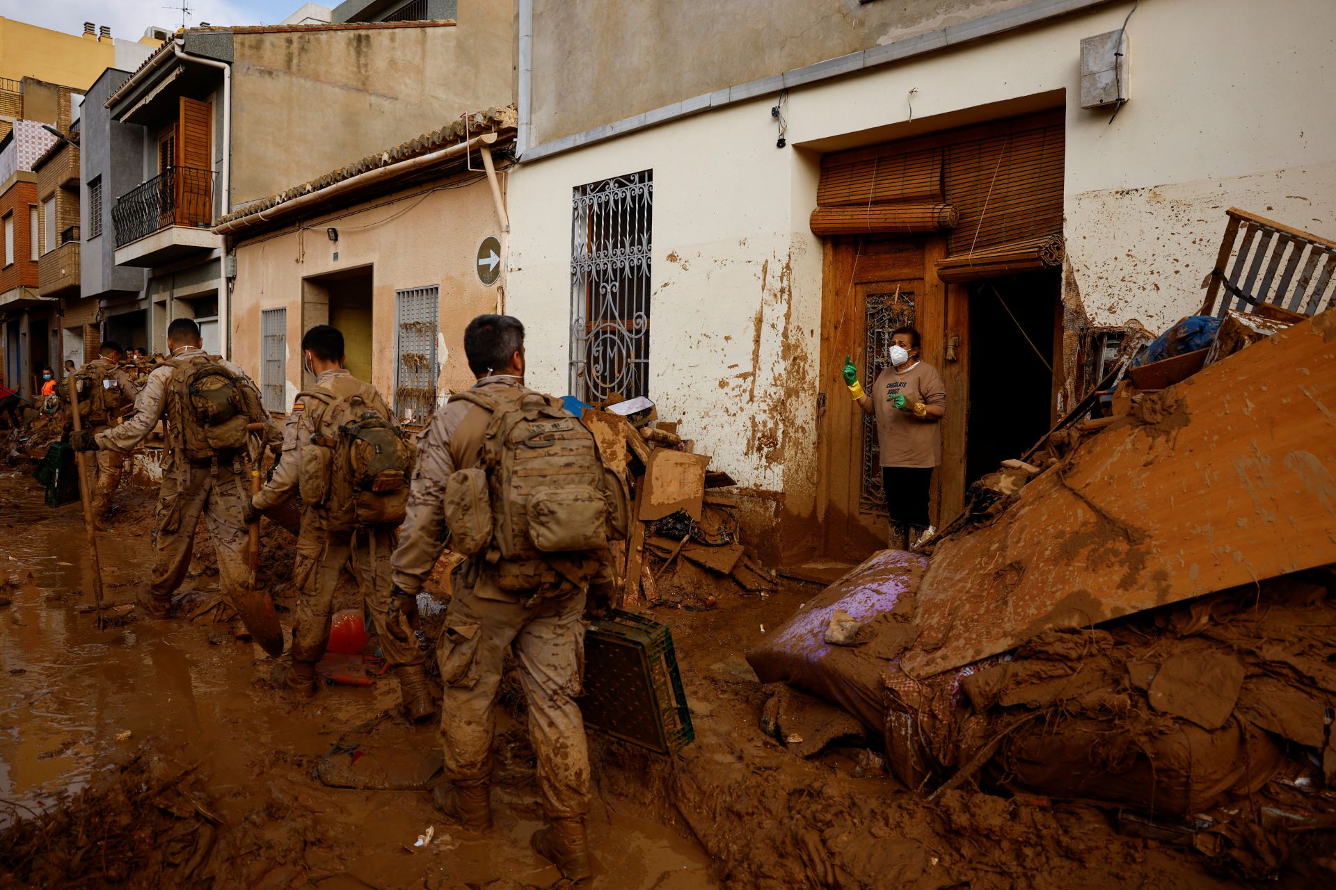 Magda Ramón pide ayuda para limpiar su casa a militares españoles, tras las inundaciones provocadas por las fuertes lluvias, en Massanassa, cerca de Valencia