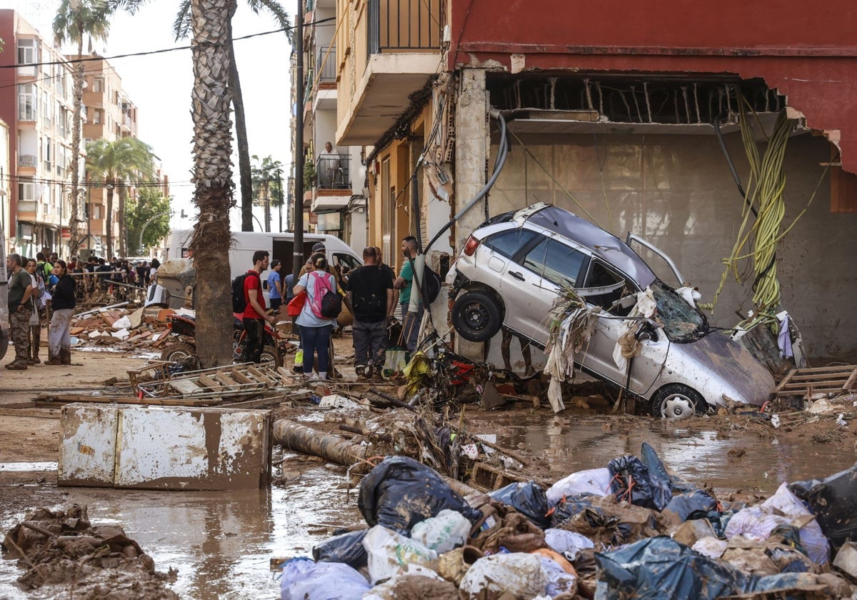 Varias personas limpian los estragos ocasionados por la DANA, en Paiporta, Valencia