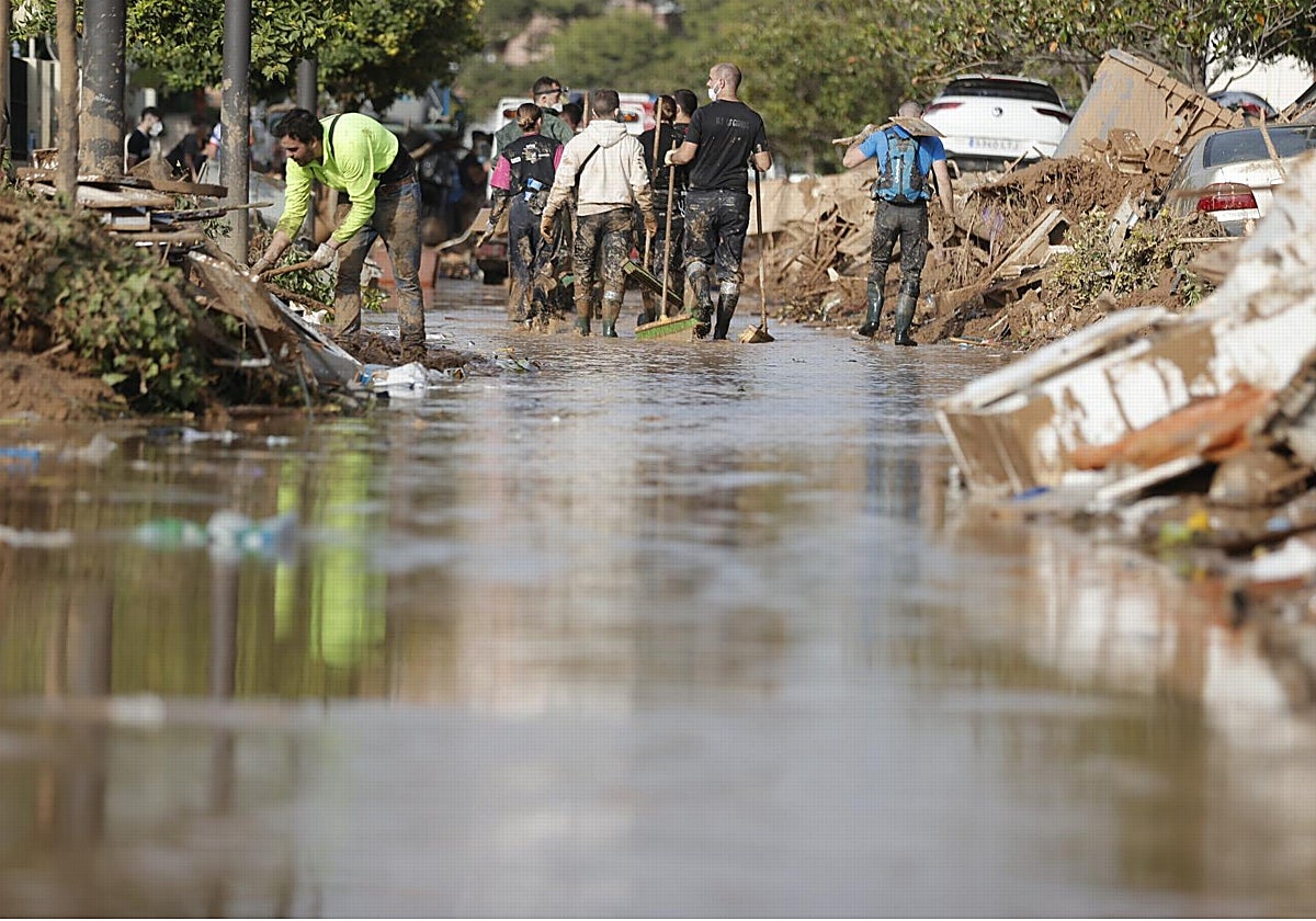 Vecinos y voluntarios en una calle de Paiporta, este martes