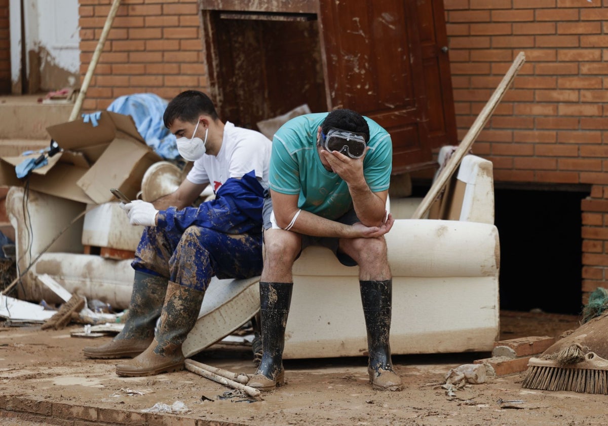 Voluntarios se toman un descanso de las labores de limpieza en Paiporta (Valencia)