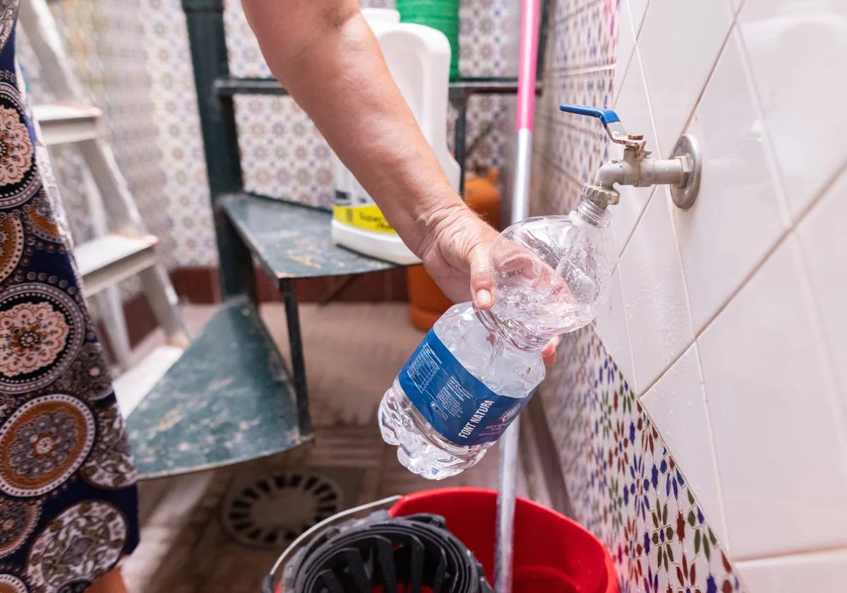 Una mujer llena una botella de agua