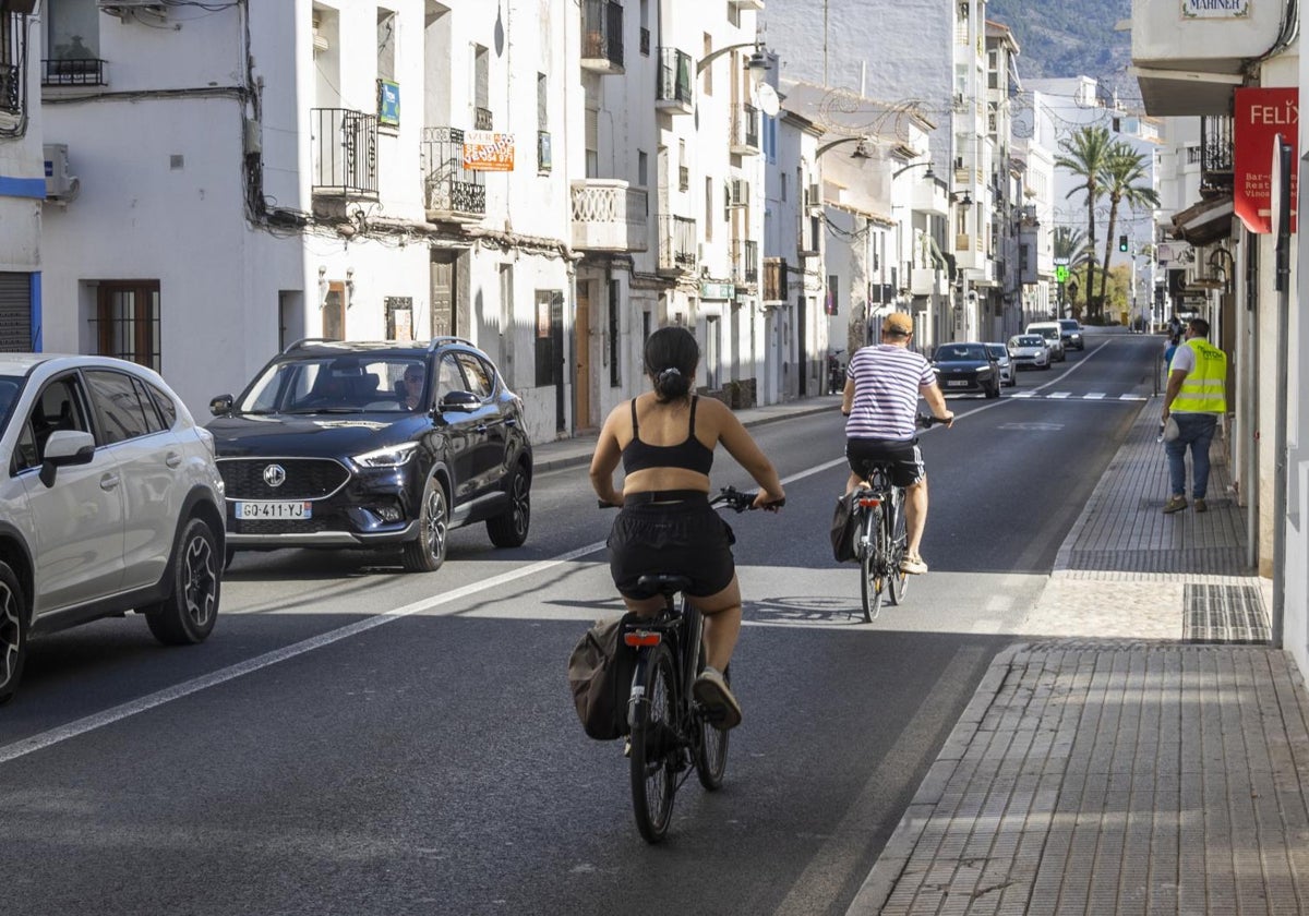 Dos ciclistas circulan por una calle de Altea (Alicante)