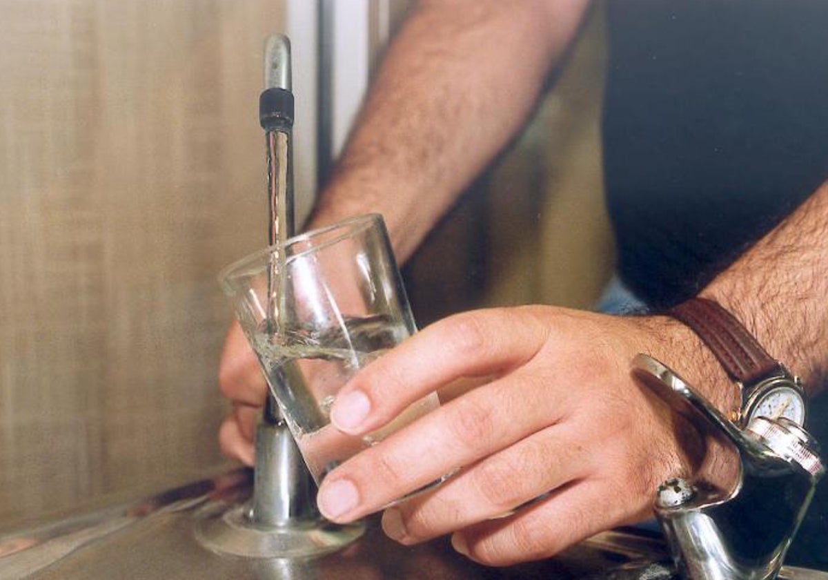 Un hombre se sirve un vaso de agua del grifo en una imagen de archivo