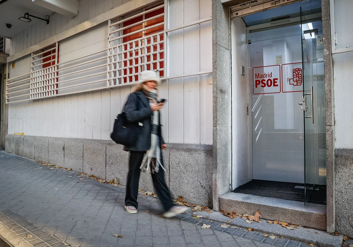 Una mujer pasa por la puerta de la sede madrileña del PSOE de Madrid