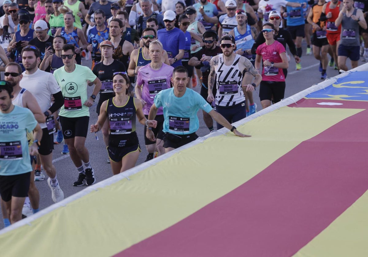 Un corredor toca la bandera de la Comunidad Valenciana en la Maratón Valencia Trinidad Alfonso, este domingo