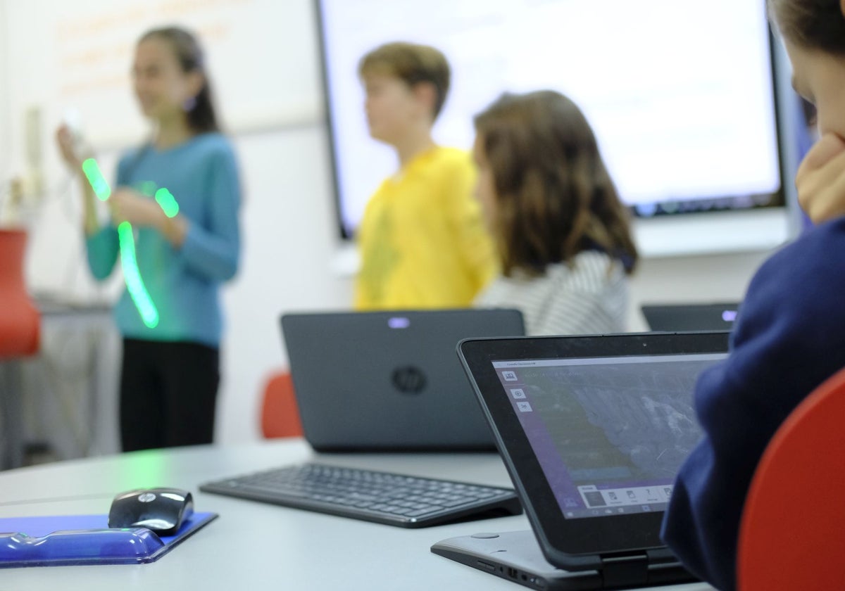 Alumnos en clase con tabletas y ordenadores