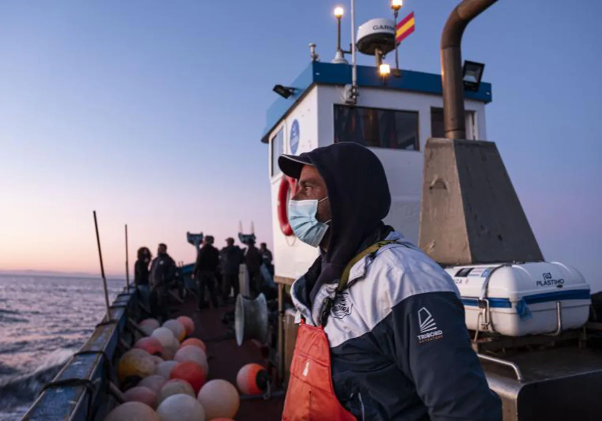 Imagen de un pescador en un barco faenando en Cádiz