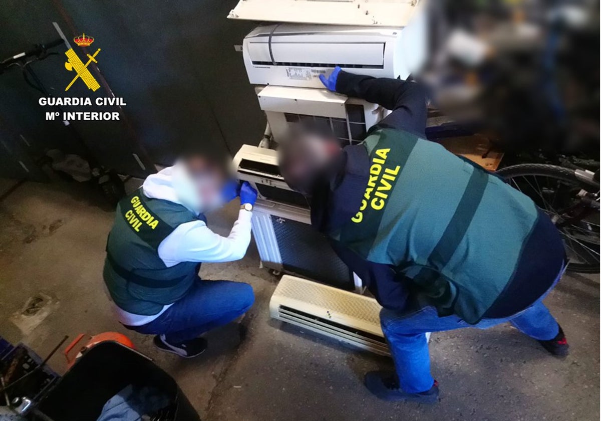 Investigadores de la Guardia Civil revisan uno de los aparatos de aire acondicionado robador por el ladrón reincidente