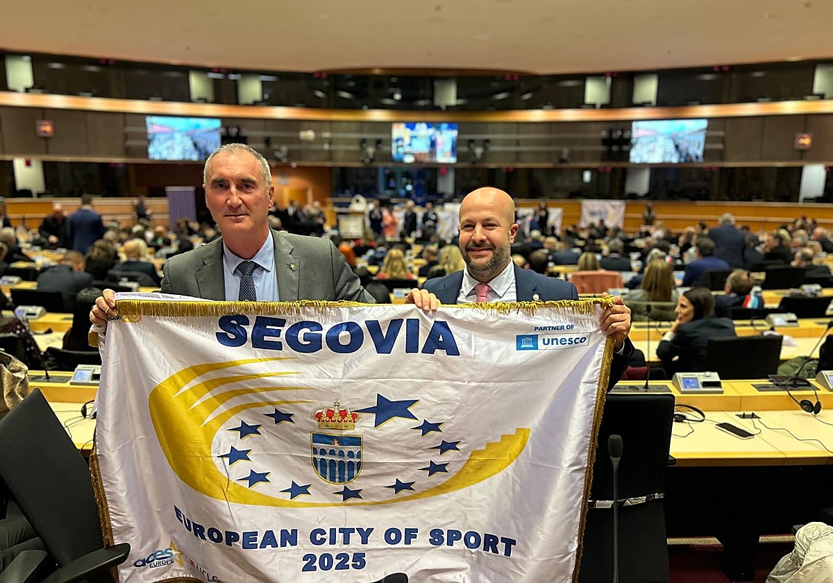 El alcalde de Segovia, José Mazarías, y el concejal Jesús Garrido, con la bandera que acredita la 'Ciudad Europea del Deporte'