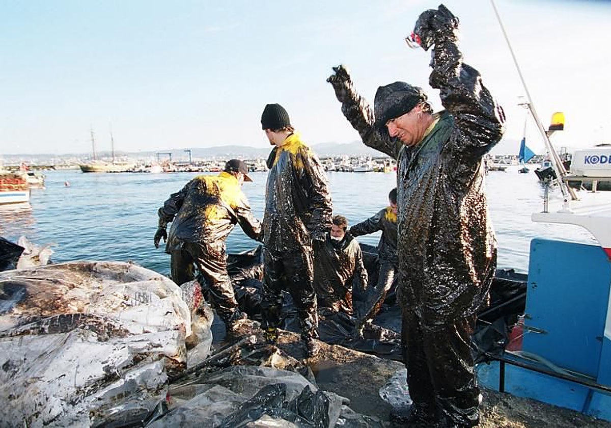 Un grupo de marineros, de vuelta tras realizar trabajos de limpieza de chapapote en la costa gallega (archivo, 2002)