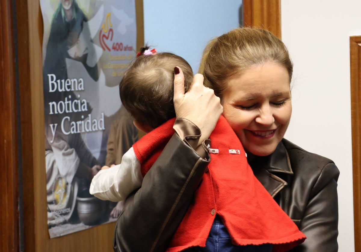 La consejera de Familia y Asuntos Sociales, Ana Dávila, con uno de los pequeños del centro Hogar Casa Belén