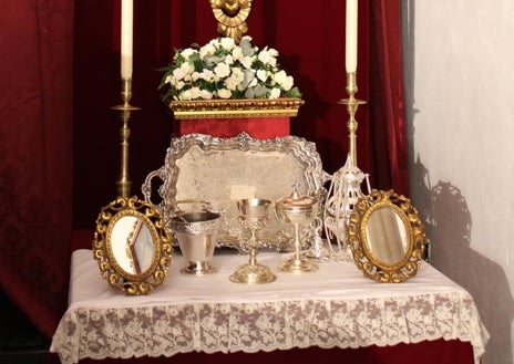 Imagen secundaria 1 - En la imagen superior, el altar de cultos de la Esperanza con las nuevas credencias a modo de consolas. En la inferior izquierda, detalle de este estreno. A la derecha, la Esperanza luce la toca de sobremanto restaurada, ante la fachada del santuario del Carmen (San Cayetano), el domingo