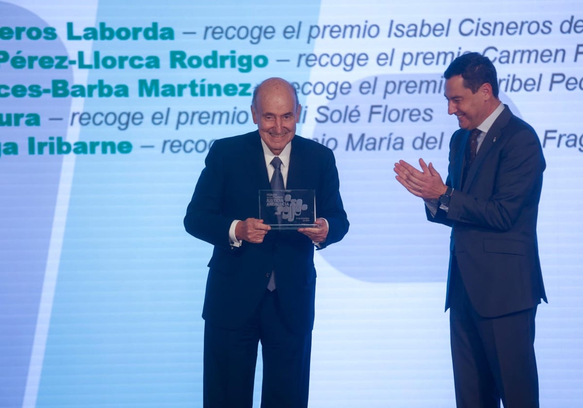 Miquel Roca recibe el premio de manos del presidente andaluz, Juanma Moreno