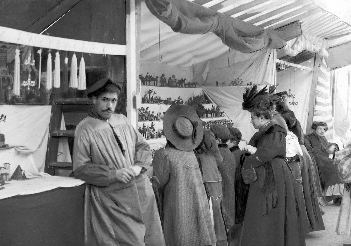 Puestos de Navidad en la plaza de Santa Cruz, en 1906, con un vendedor mirando a cámara