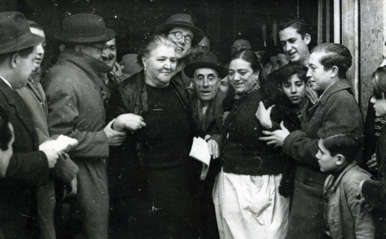 Imagen principal - Arriba, Doña Manolita, la lotera, en 1943 tras dar un premio. Abajo, vendedores de pavos en la Plaza Mayor (izq), y los puestos en la plaza de Santa Cruz, en 1955