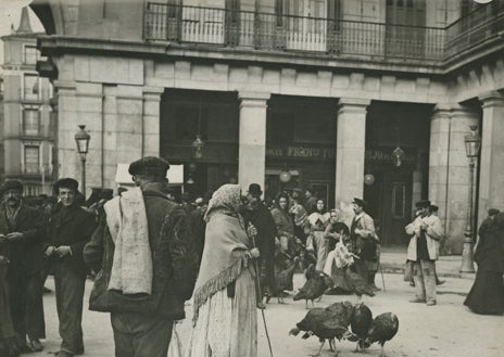 Imagen secundaria 1 - Arriba, Doña Manolita, la lotera, en 1943 tras dar un premio. Abajo, vendedores de pavos en la Plaza Mayor (izq), y los puestos en la plaza de Santa Cruz, en 1955