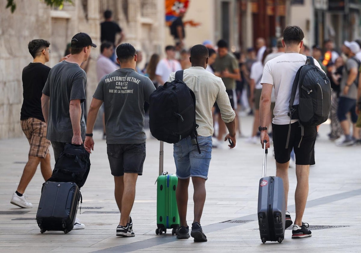 Imagen de archivo de turistas paseando con sus maletas por el centro de Valencia