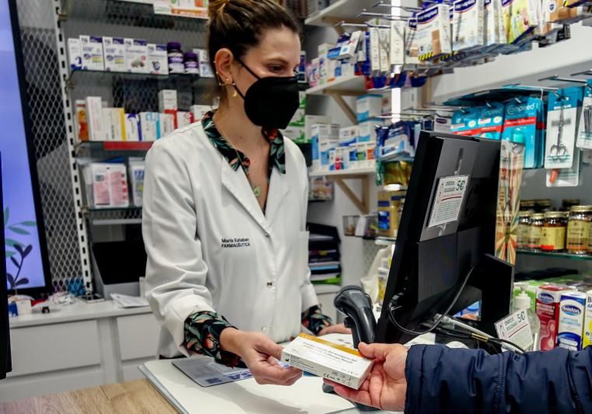 Una farmacia dispensando un medicamento, en una imagen de archivo