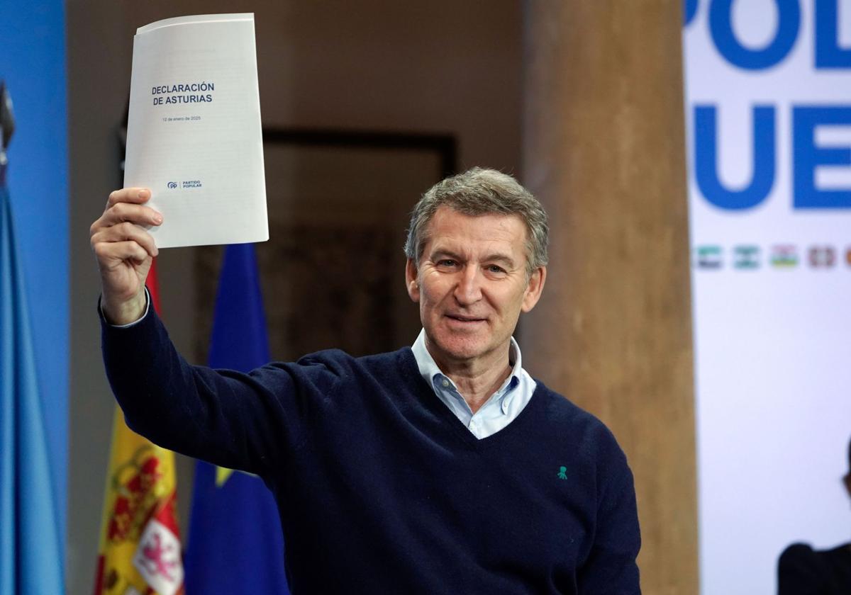 Alberto Núñez Feijóo sostiene en la mano la 'Declaración de Asturias' del PP