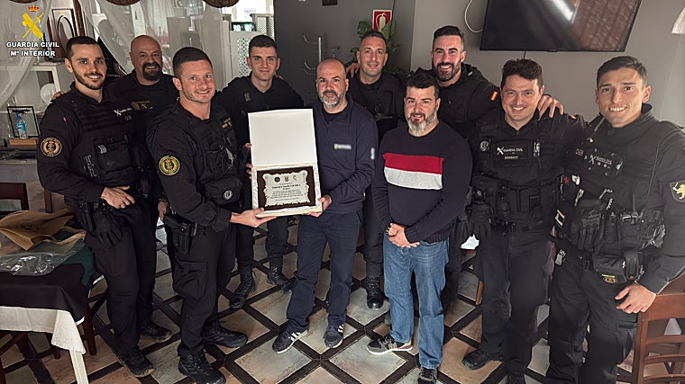 La familia del rescatado entrega una placa de agradecimiento a los agentes que participaron en el operativo