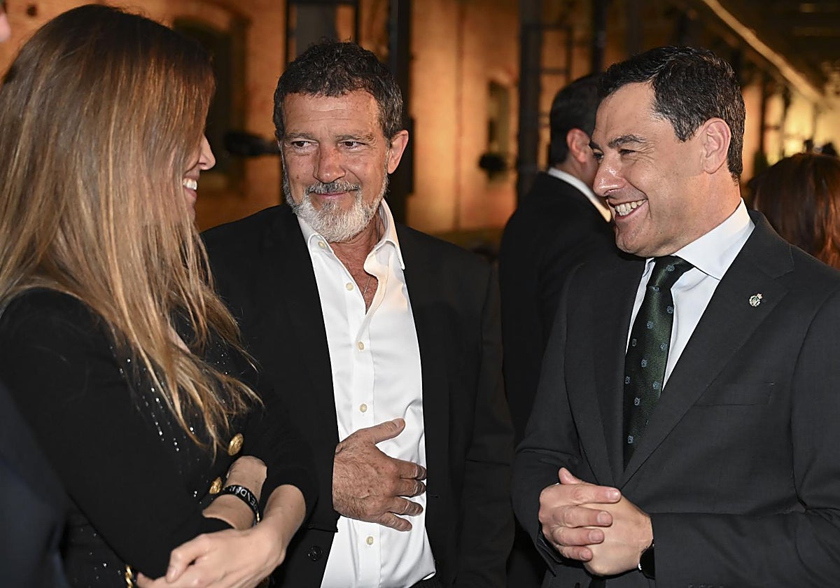 El presidente de la Junta, Juanma Moreno (d), el actor Antonio Banderas (c) y su pareja Nicole Kimpel (i), en Madrid