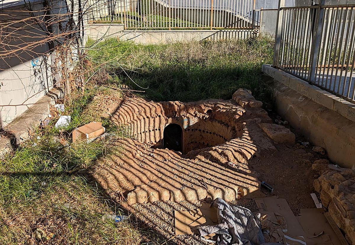 Horno califal de Ollerías en estado de abandono, con desperdicios y vegetación.