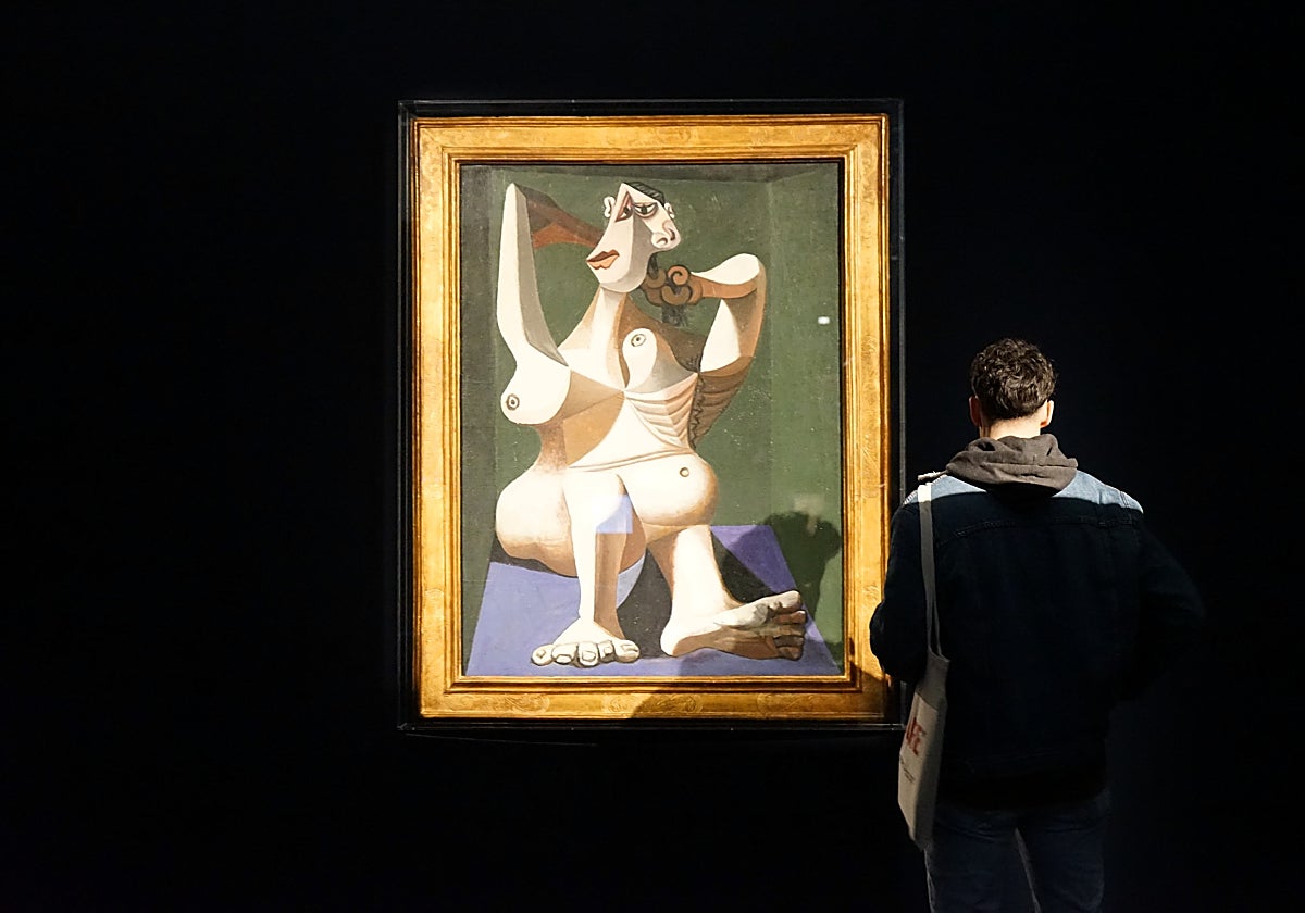 Un joven contempla 'Mujer peinándose' de Picasso, obra que podrá verse hasta el 30 de abril en Málaga
