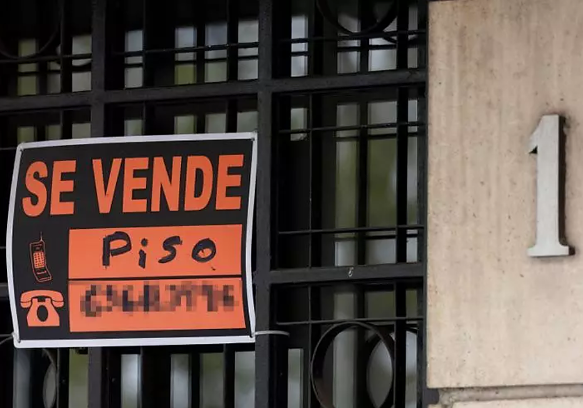 Vista de un cartel de 'Se vende' en un portal de un edificio