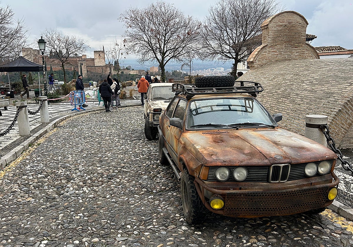 Coches oxidados y un ambiente sórdido contrastan con la serena estampa de la Alhambra