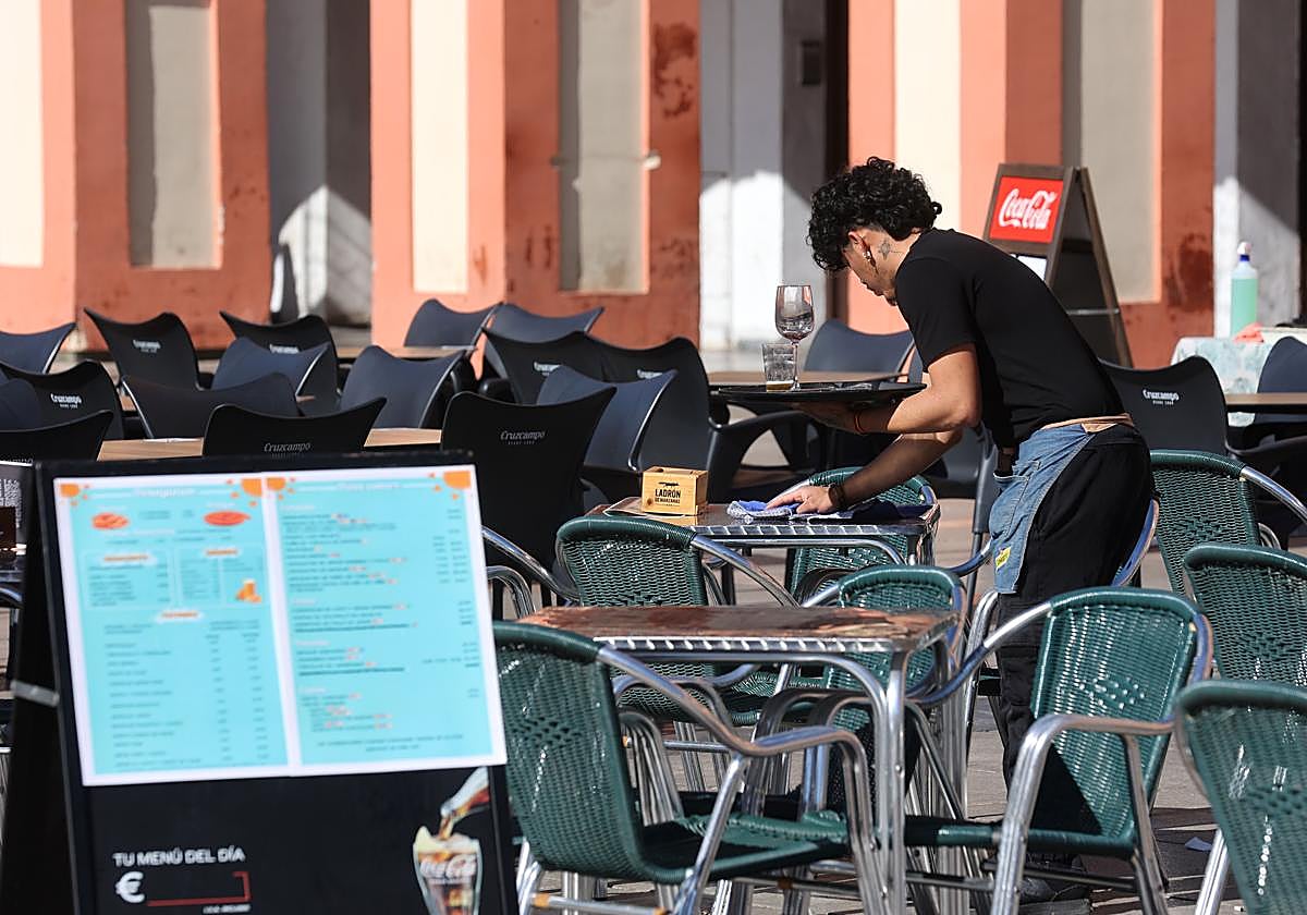 Un camarero, este miércoels limpiando una mesa en la Corredera