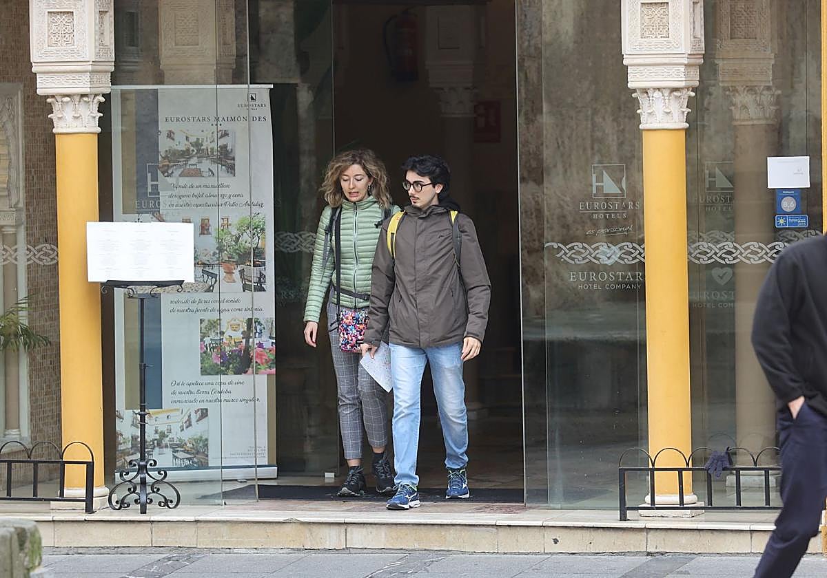 Dos turistas salen de un hotel en Córdoba