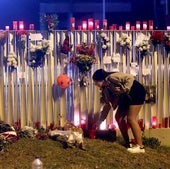 Una joven enciende una vela en recuerdo del joven asesinado