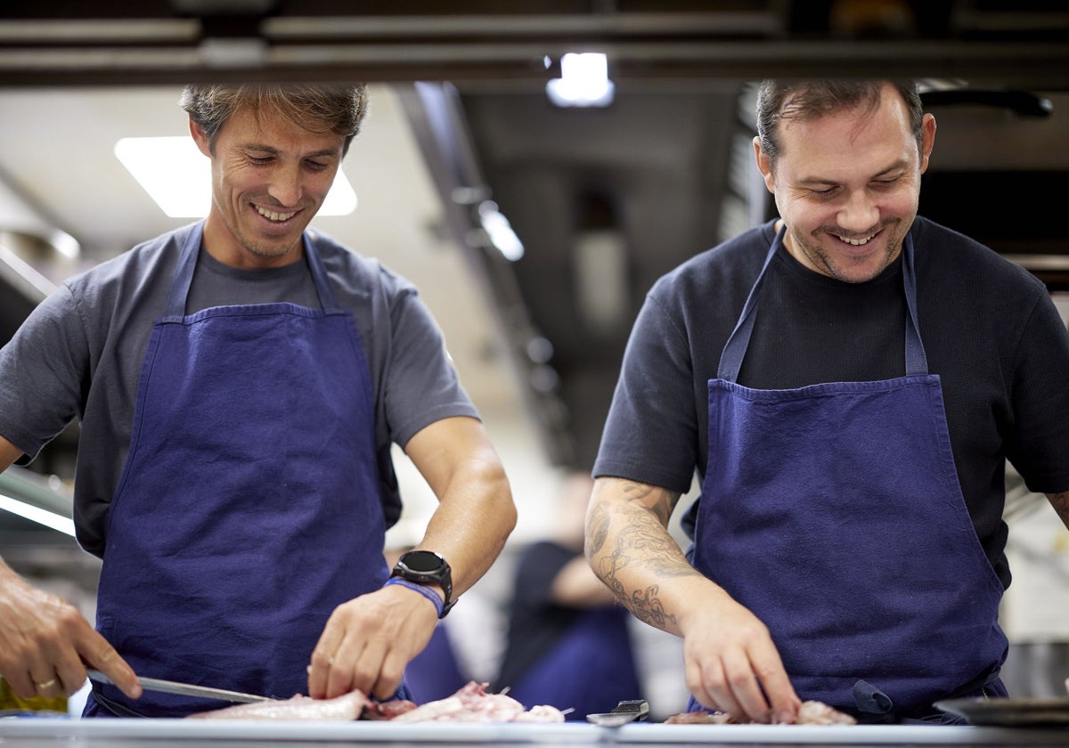 Nino Redruello y Manu Villalba preparan los productos que por la mañana han comprado en la Boquería con los comensales a los que sirven una cena totalmente creativa