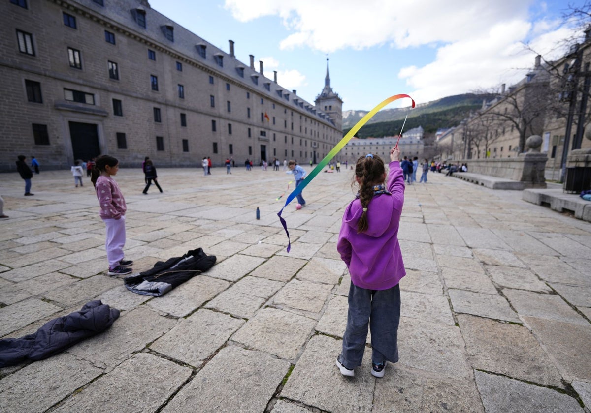 Un grupo de alumnos juega en la explanada situada junto a una entrada de turistas al monasterio