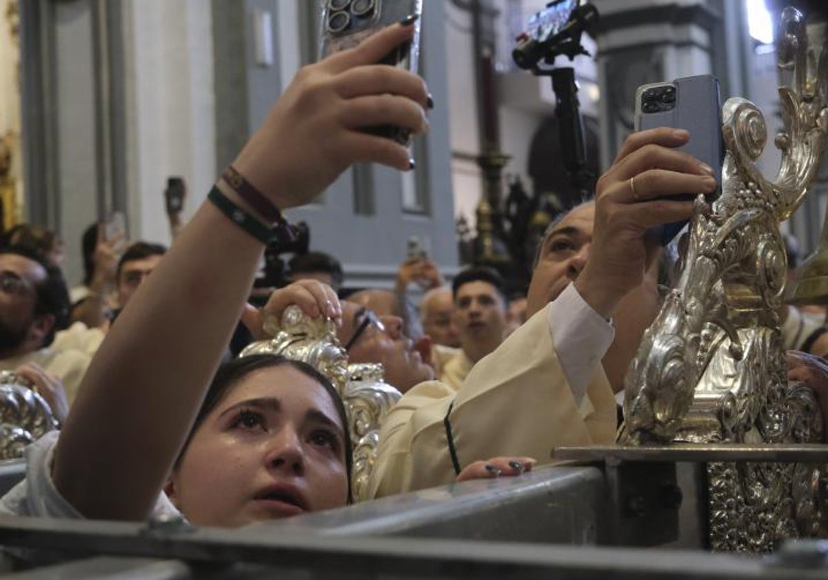 Jóvenes fotografian un paso en la Semana Santa de Málaga