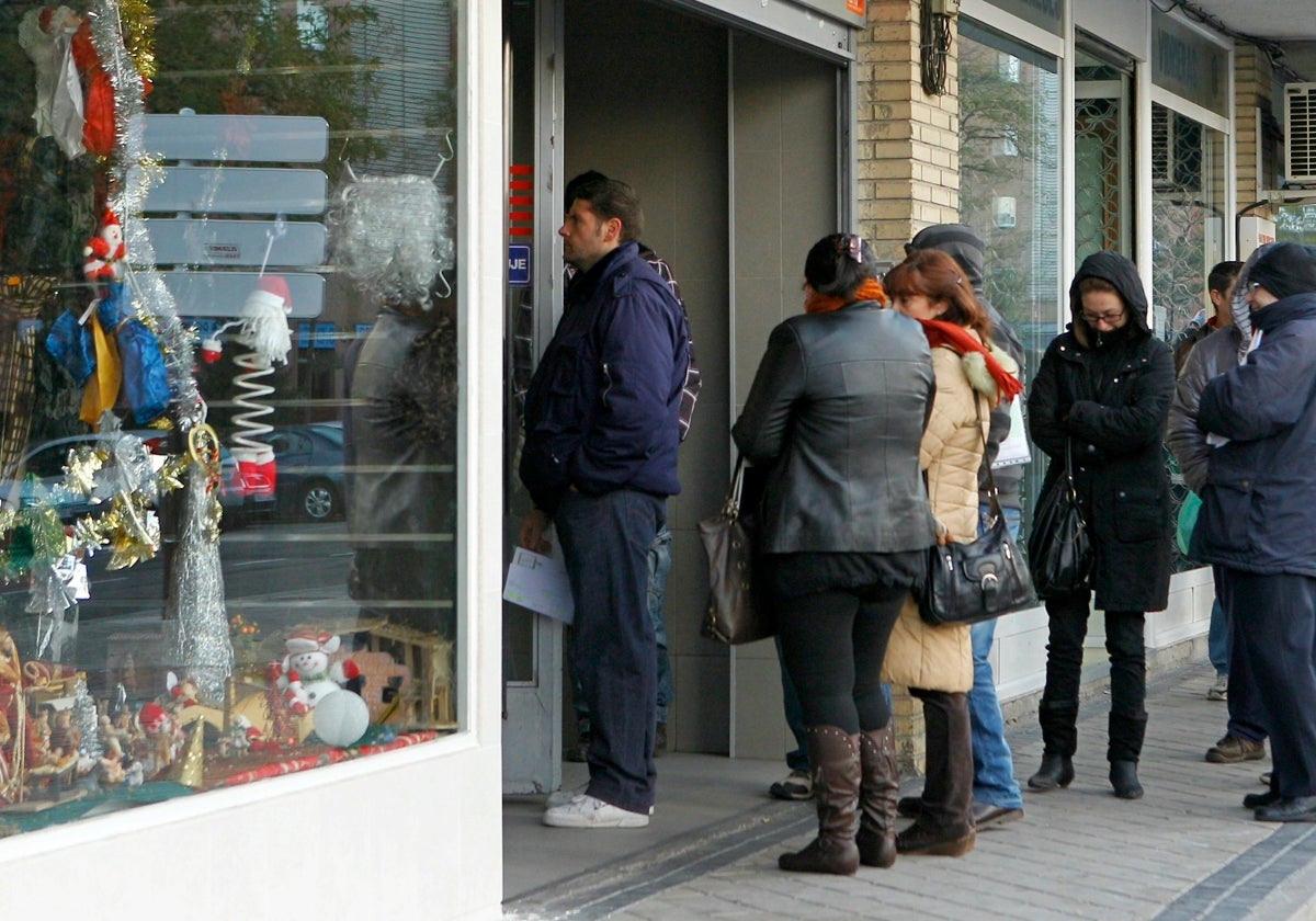 Personas aguardando cola en una oficina de empleo