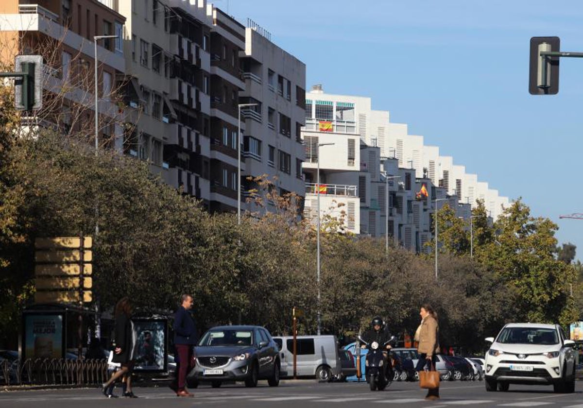 Peatones cruzando en un barrio con numerosos pisos de alquiler