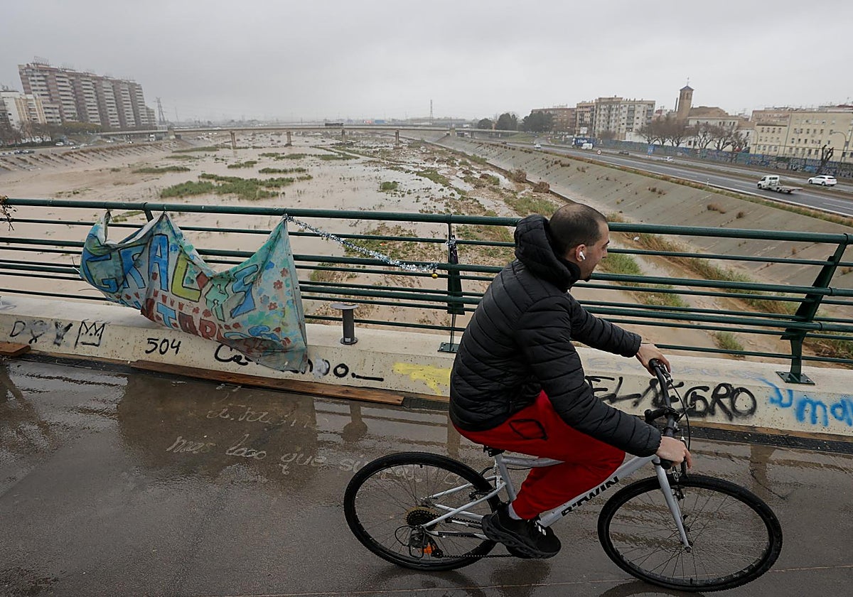 Una persona cruza un puente sobre el nuevo cauce del Turia en Valencia