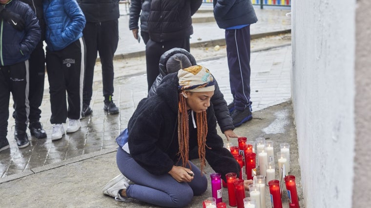 Una joven pone una vela en el altar en homenaje a William, el 5 de diciembre de 2022, en Villaverde