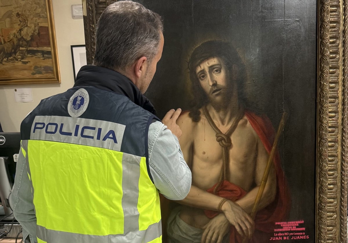 Un investigador de la Policía de la Generalitat Valenciana observa el cuadro falso de una obra de Juan de Juanes