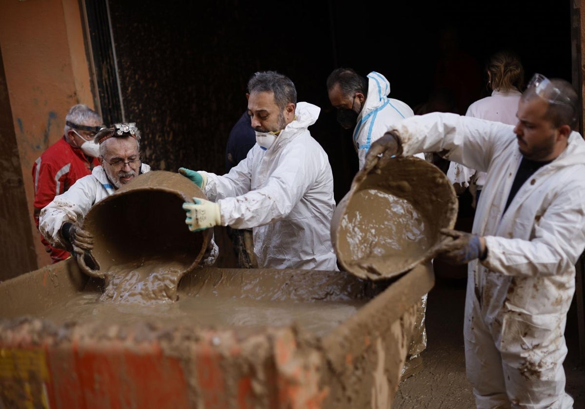 Voluntarios limpian un garaje de Paiporta tras la dana en Valencia