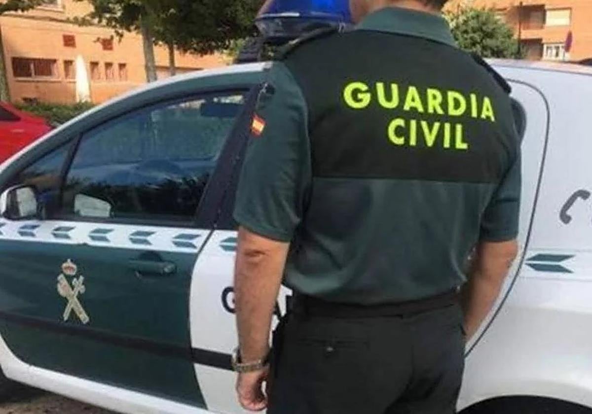 Fotografía de archivo de un agente y un vehícuo de la Guardia Civil